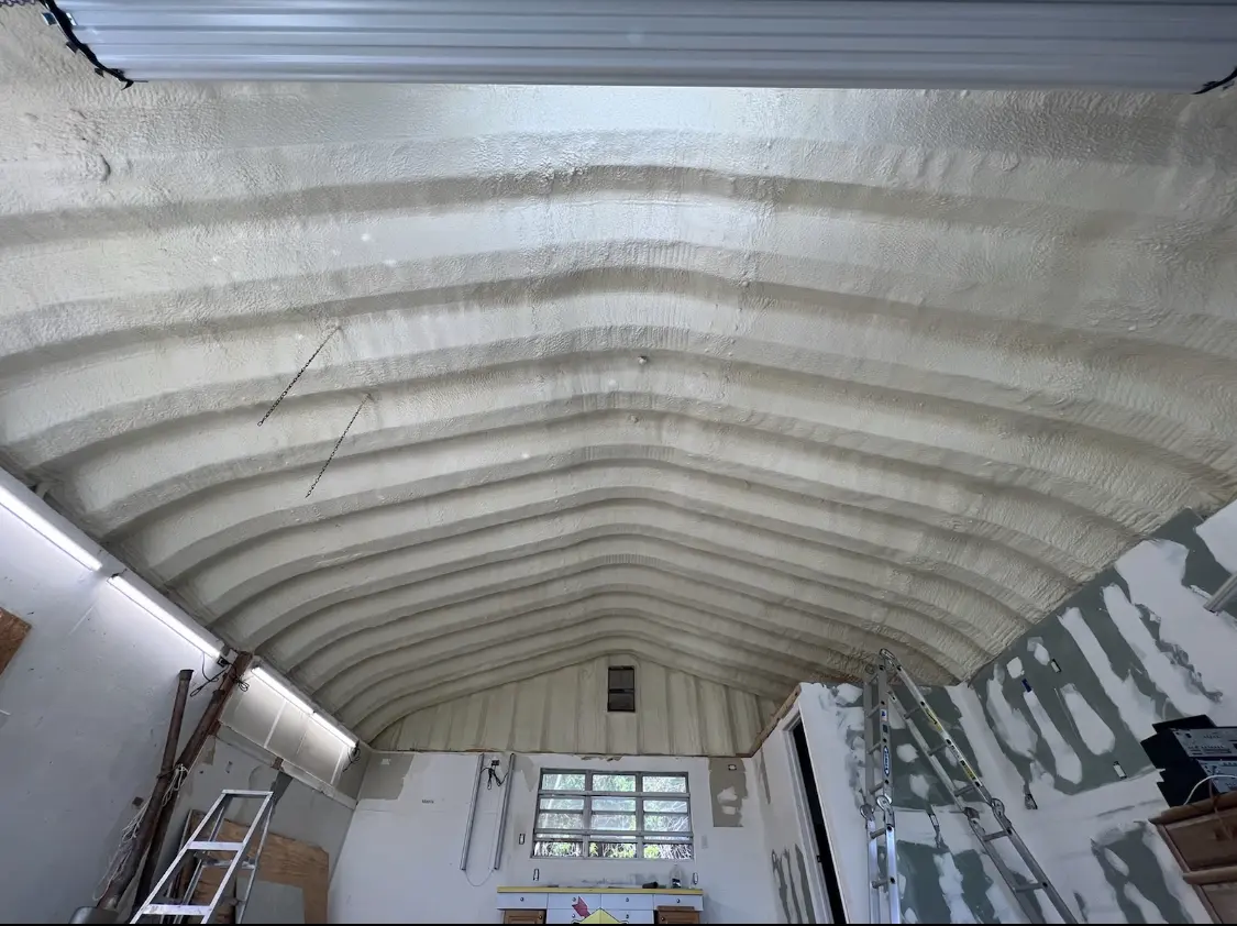 Spray polyurethane foam applied to the underside of a metal roof deck in Tarrant